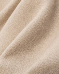 Close-up of a beige fabric, showcasing the soft texture of a winter scarf.