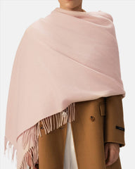 A model showcases a lightweight beige scarf, styled as a shawl, perfect for women's fashion.