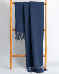 A navy blue women's scarf and shawl draped elegantly over a wooden stand.