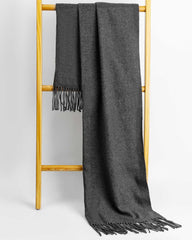 A gray women's scarf and shawl draped elegantly over a wooden stand.