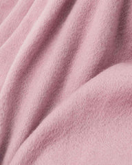 A close-up view of a soft pink scarf, showcasing its texture and warmth, reminiscent of a cozy scarf or shawl.