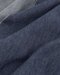 Close-up of a reversible scarf featuring a blue and grey fabric, showcasing its intricate texture and color blend.