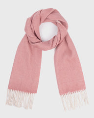 A reversible pink scarf made of wool, adorned with fringes, offering both comfort and style.