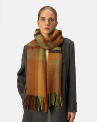 A woman wearing a stylish brown and green plaid scarf, adding a cozy touch to her outfit.