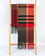 A cozy red, black, and grey plaid scarf draped over a rustic wooden ladder, adding warmth to the scene.