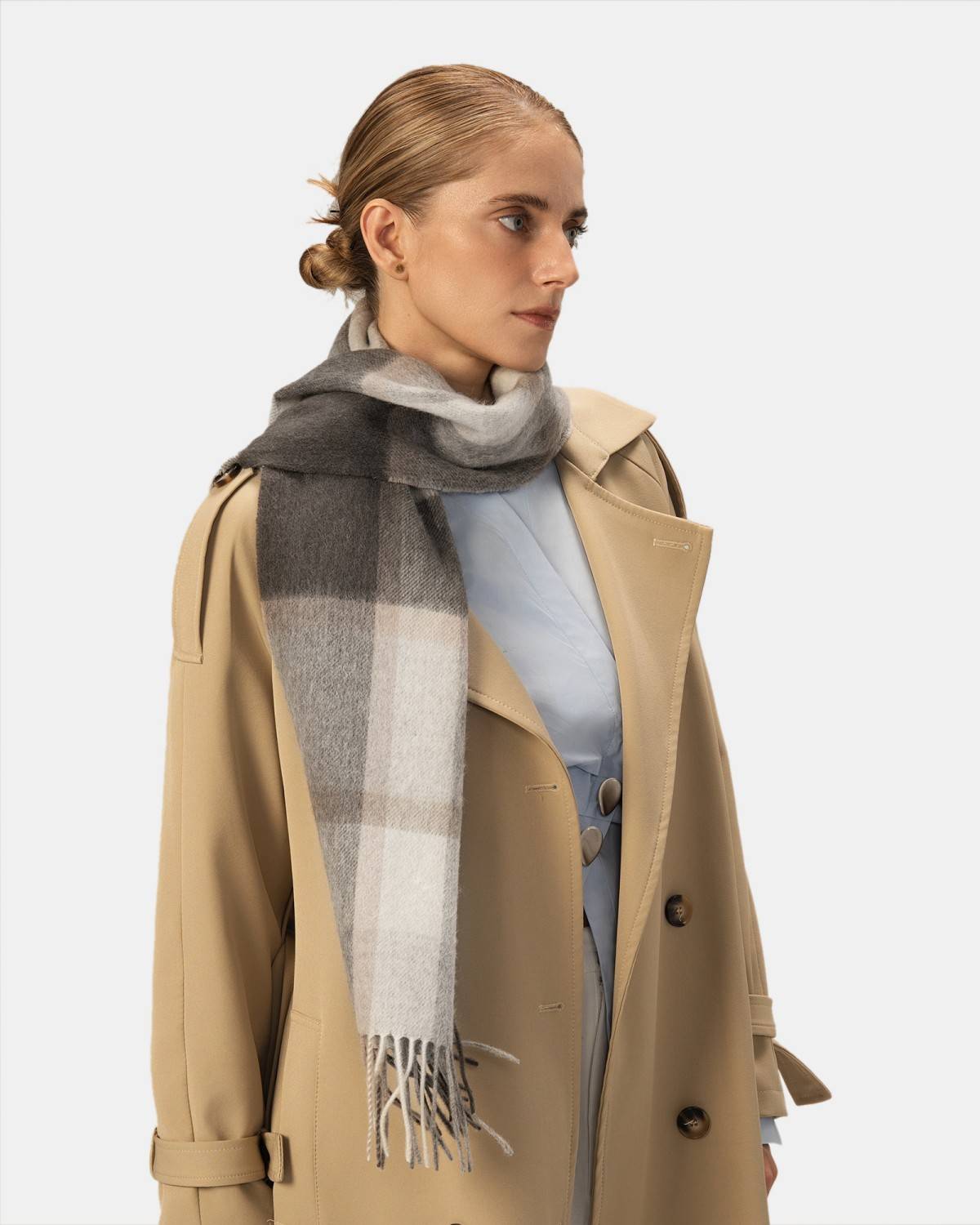 A model wears a classic winter scarf in grey and beige, ideal for adding elegance to winter outfits.
