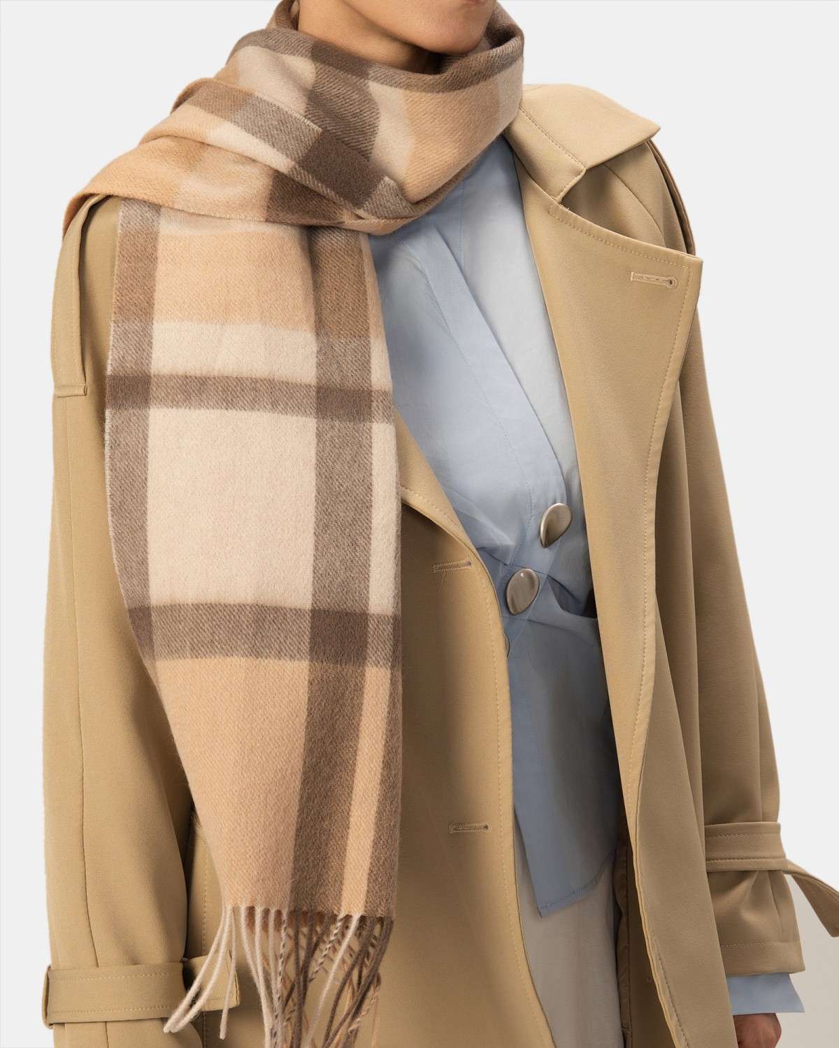 A model showcases a classic camel check wool scarf, featuring a coffee and gray plaid design, perfect for winter.