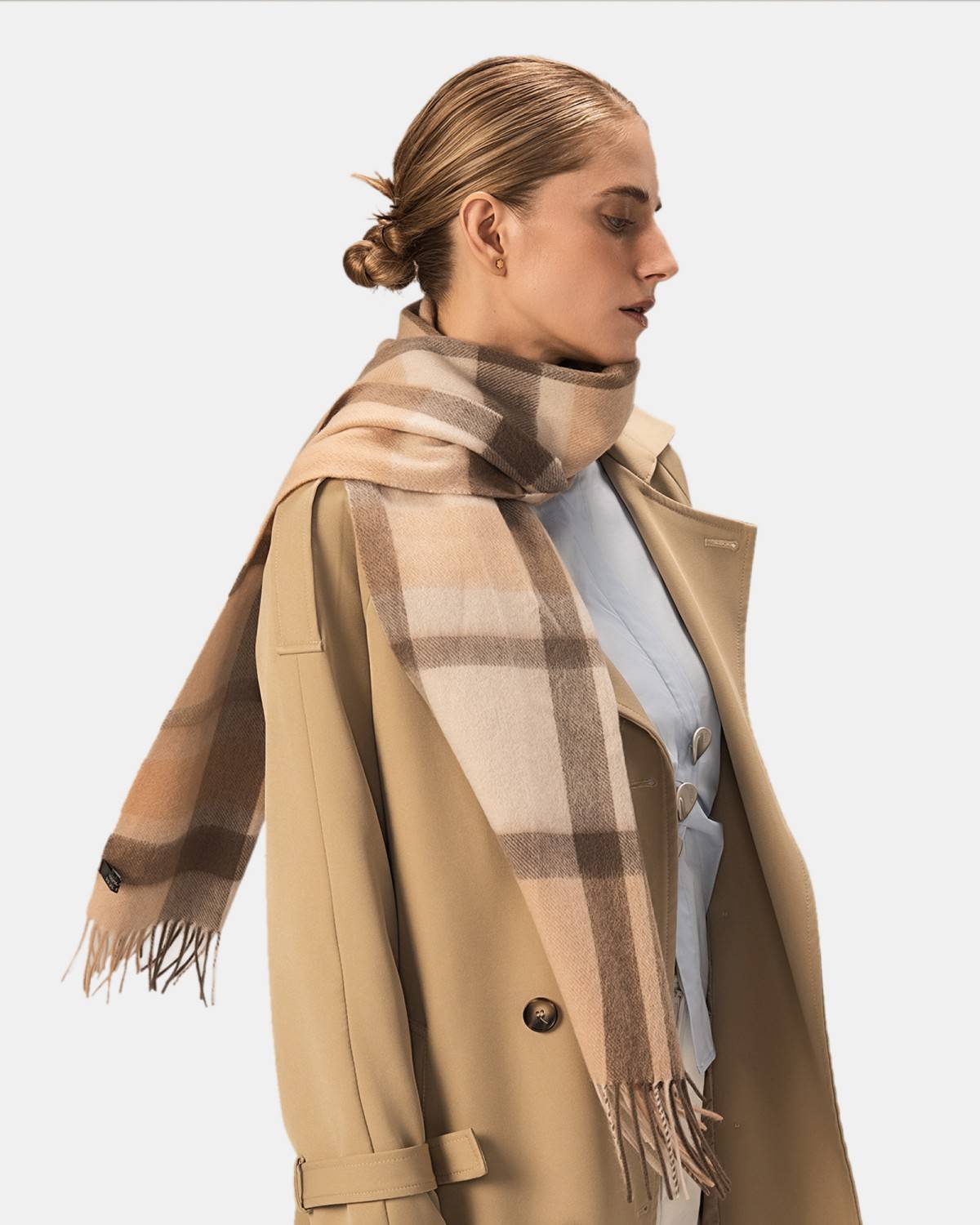 A model wears a camel check scarf with a coffee and gray plaid pattern, ideal for adding warmth and style in winter.