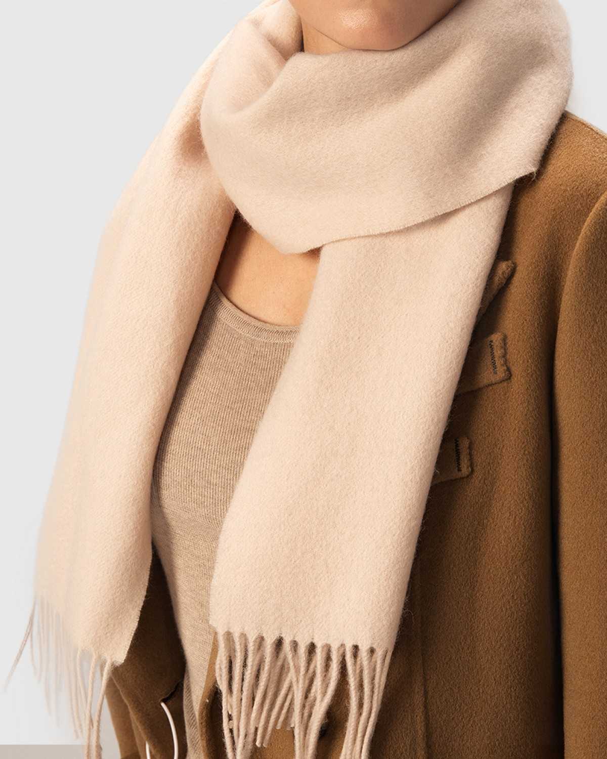 A model showcases a luxurious wool scarf, perfect for winter, highlighting its soft texture and elegant design.