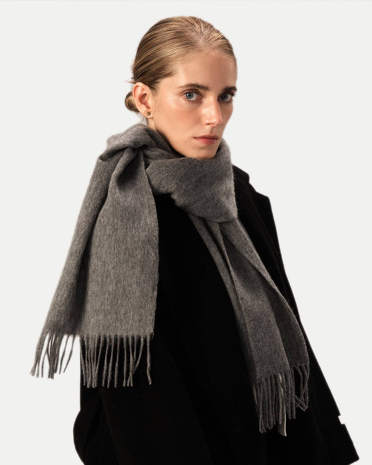 A stylish model displays a soft grey wool scarf, ideal for winter fashion and comfort.