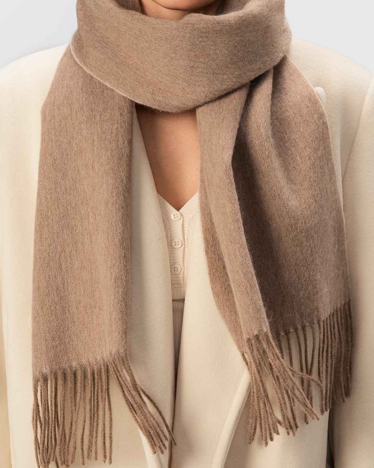 A model wearing a luxurious khaki wool 
 scarf, highlighting its warmth and style for winter.