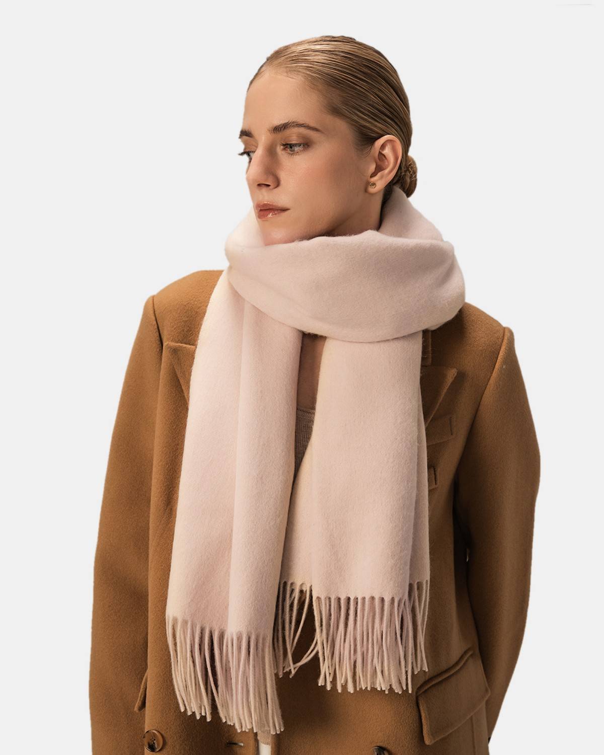 A model displays a soft beige wool scarf, highlighting its chic design as a women's accessory.