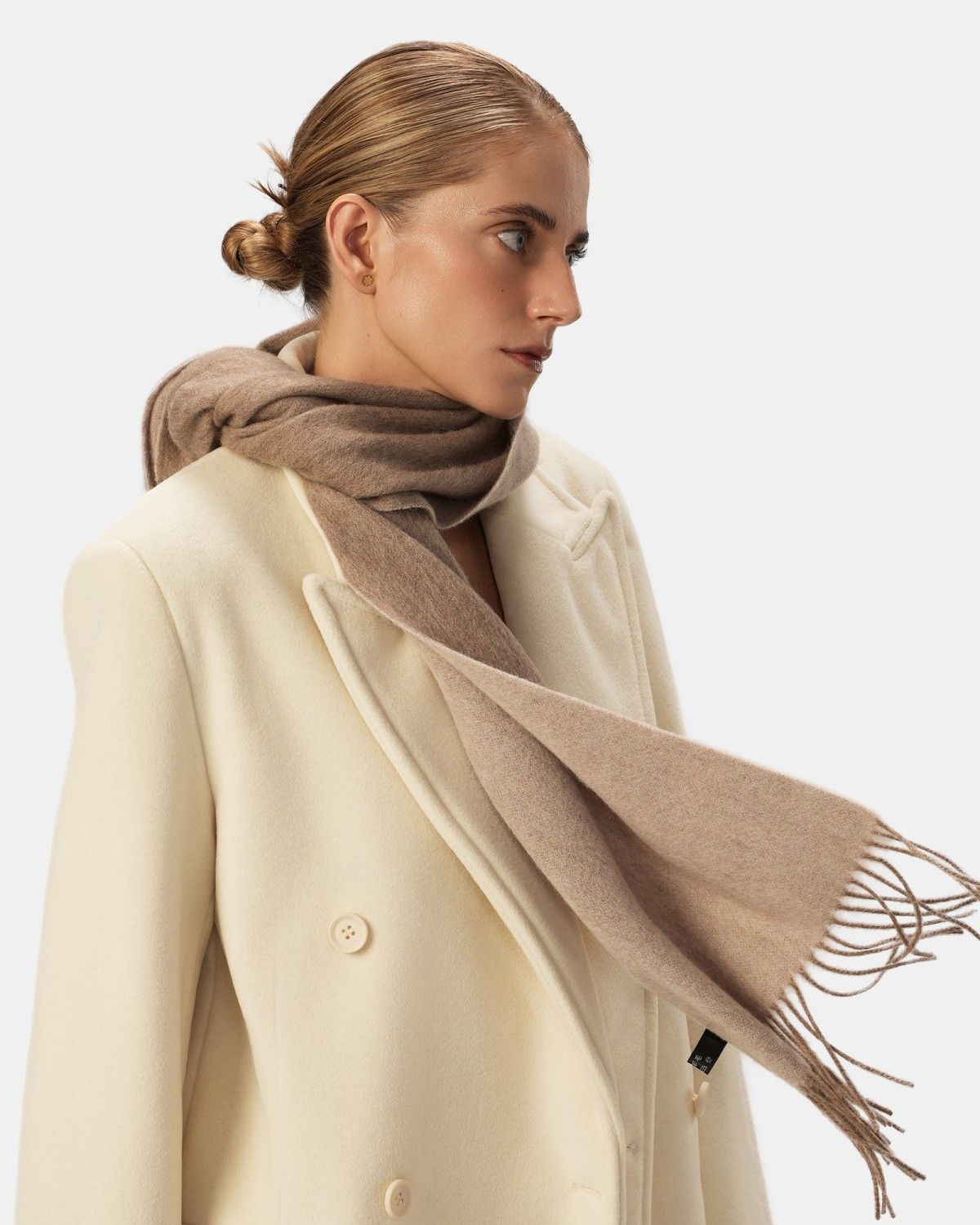 A model showcases a wool scarf, emphasizing its khaki reversible design and soft fabric.