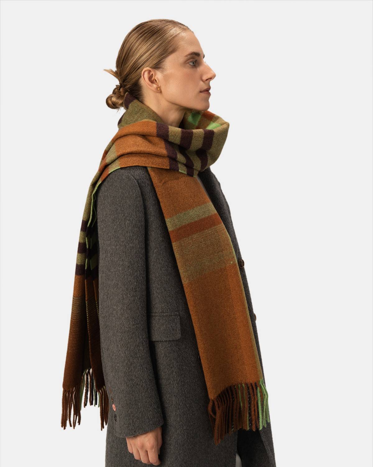 A model showcases a wool scarf featuring a stylish check pattern, adding a cozy touch to their outfit.